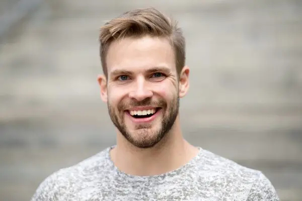 Man with perfect brilliant smile unshaven face defocused background. Guy happy emotional expression outdoors. Bearded and handsome. Man happy smiling face white brilliant teeth. Dentistry concept.